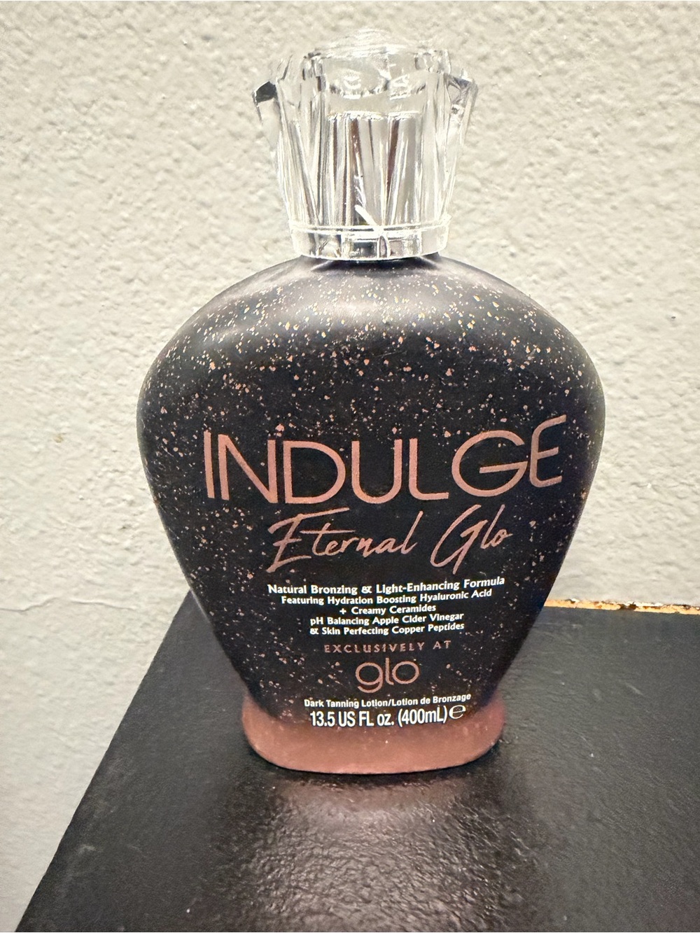 indulge Eternal Glo Bronzing Lotion in Black with Rose Gold Accents